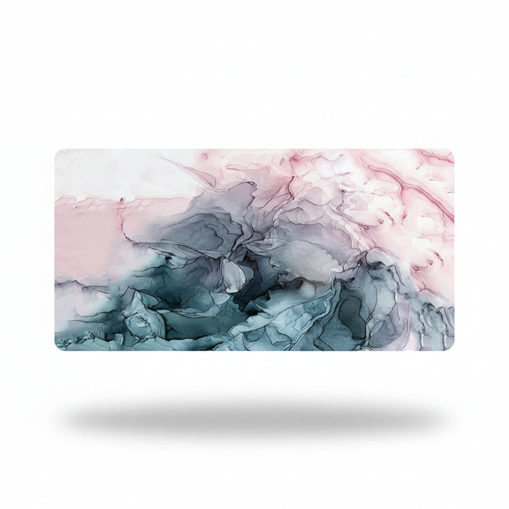A rectangular desk mat featuring a fluid ink wash design in shades of pink, gray, and blue-gray, shown against a clean white background with a soft drop shadow.