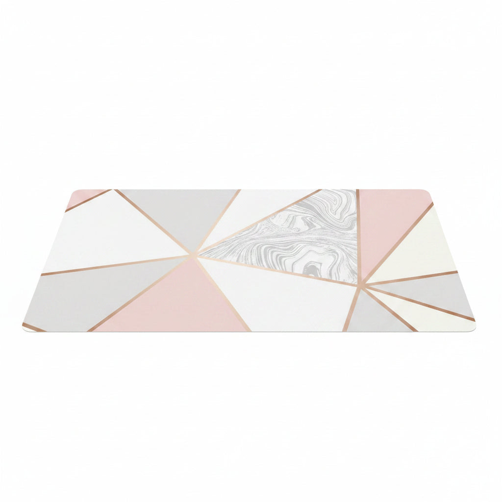 A rectangular placemat with a modern geometric design featuring pink, white, and light gray triangles separated by rose gold metallic lines, with one central triangle displaying a white and gray marble pattern.