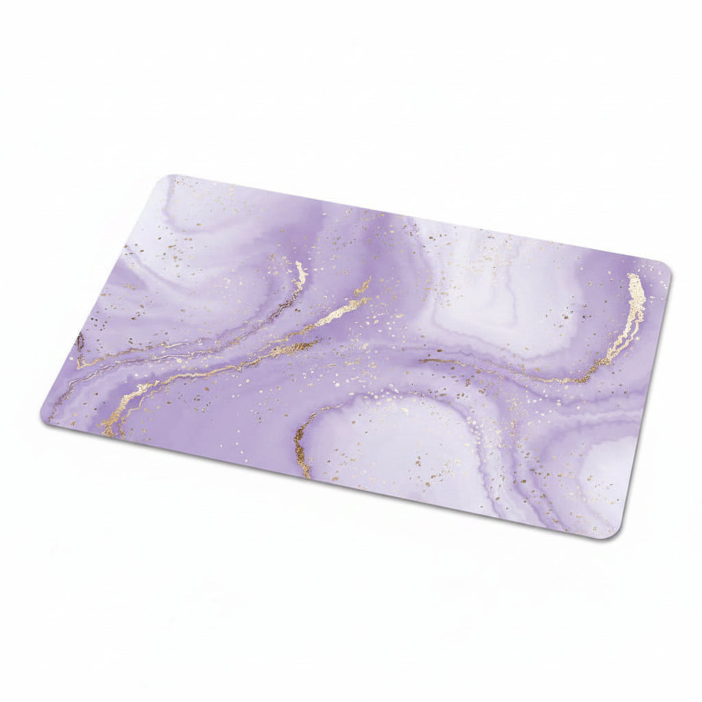 A rectangular desk mat featuring a lavender purple and white marble pattern with metallic gold veining and subtle gold glitter, shown against a plain white background.