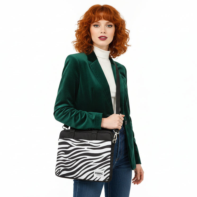 Woman wearing a green coat with a zebra-striped handbag on a white background