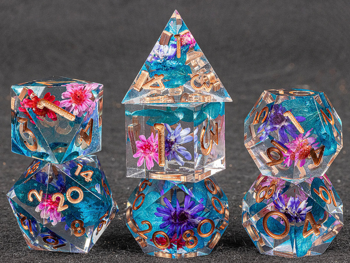 Set of colorful polyhedral dice with floral elements on a dark background