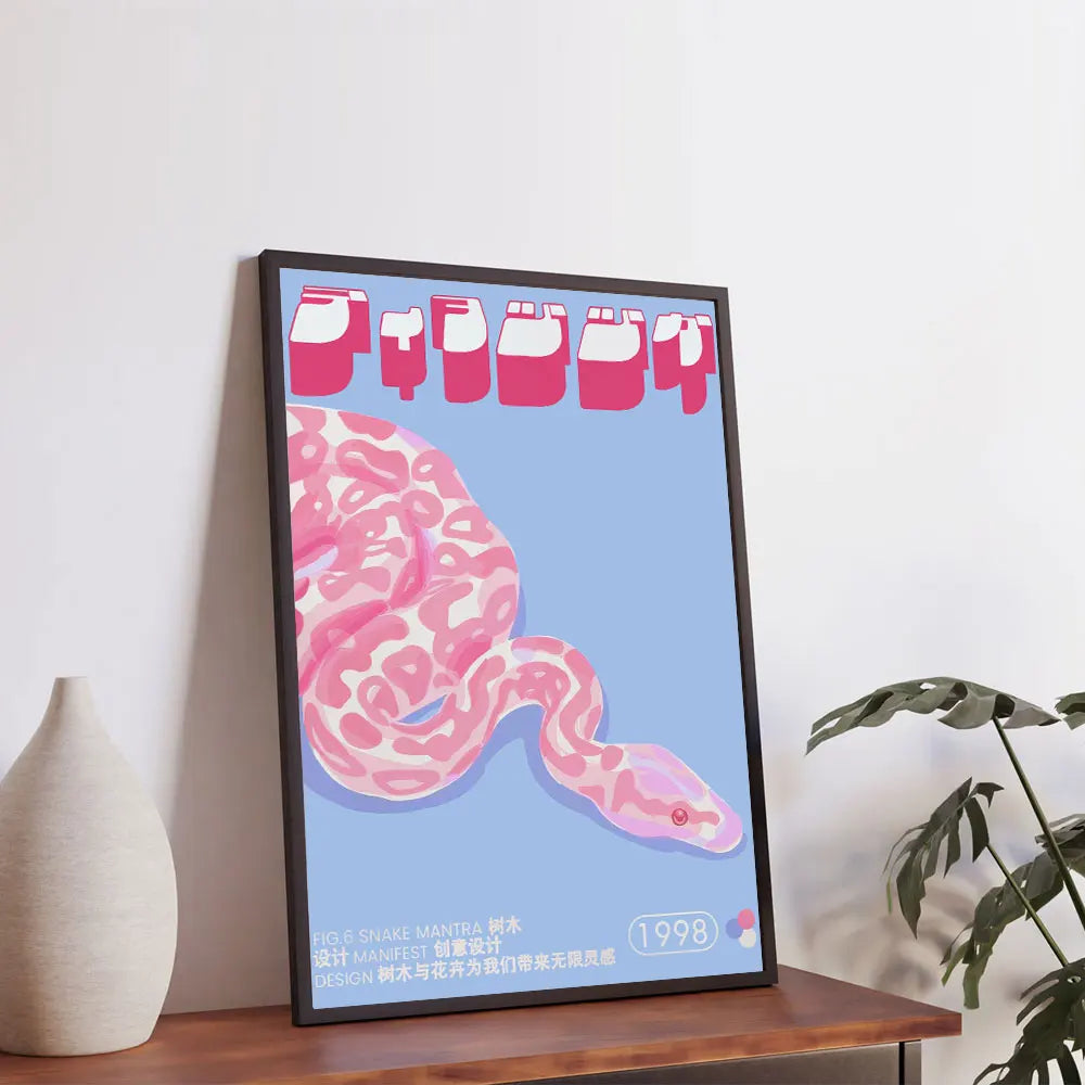 Framed artwork of a pink snake on a blue background, leaning against a white wall with a plant and vase in the foreground.