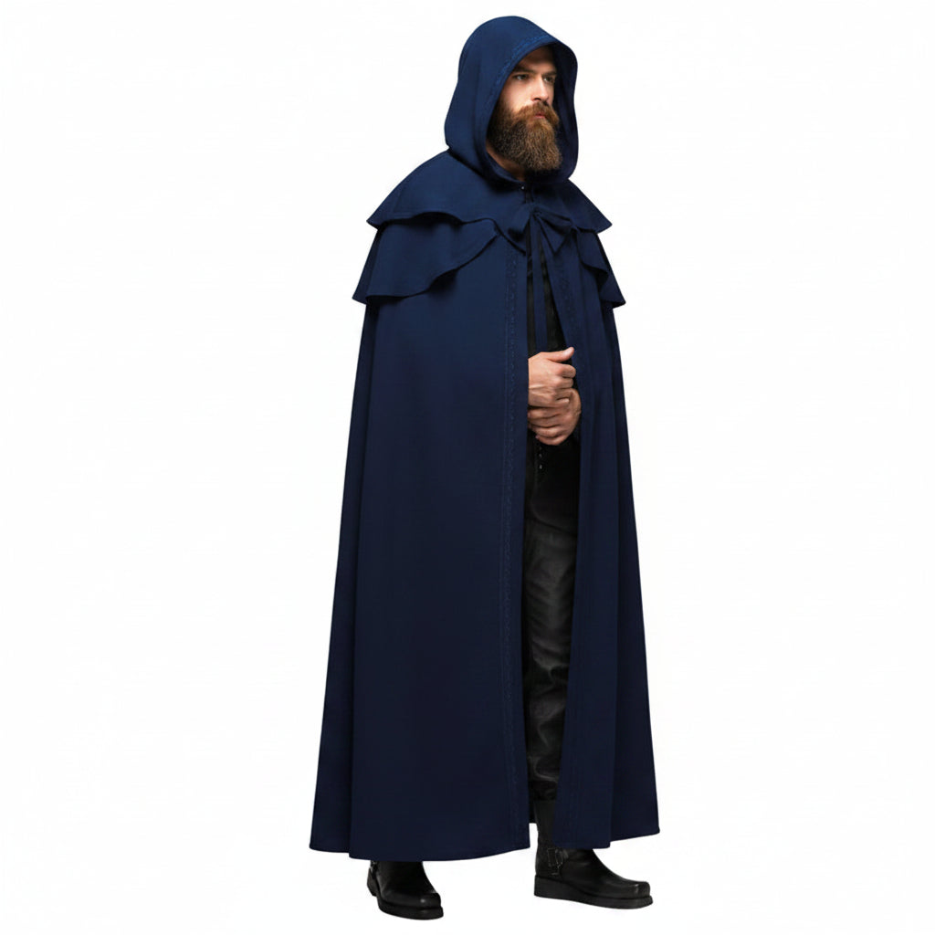 A man wearing a long, dark navy blue hooded cloak with a large collar and tie, standing against a plain white background.