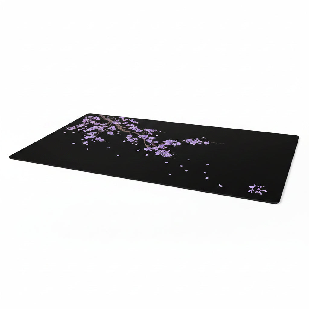 Black desk mat with cherry blossom design on a dark background