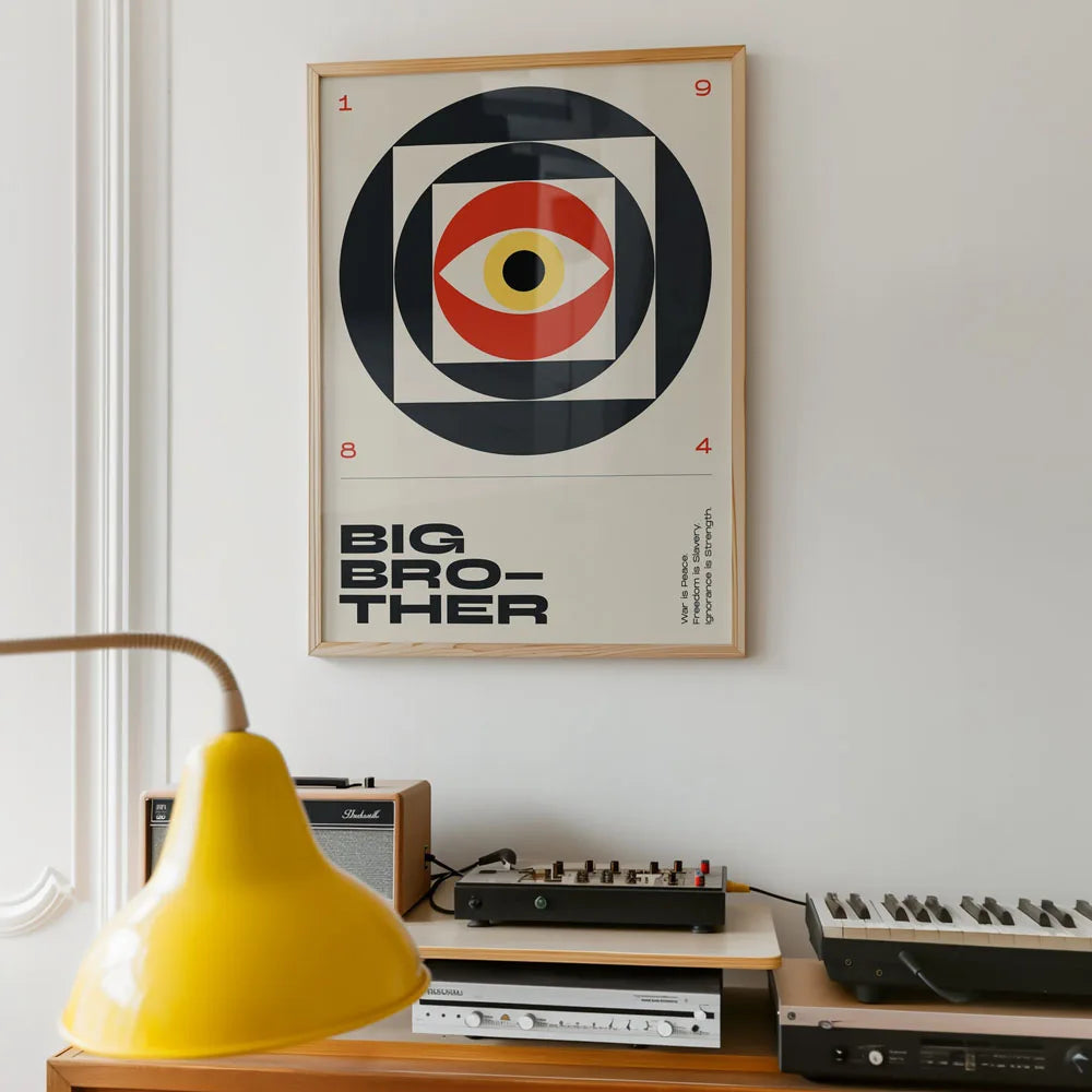 Framed poster with 'Big Brother' design on a wall above vintage electronic equipment.