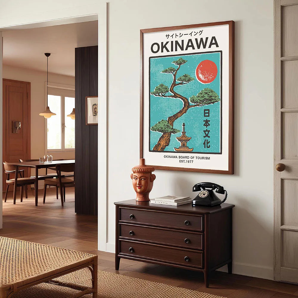 Framed Okinawa travel poster on a wall above a wooden dresser with a vintage telephone.