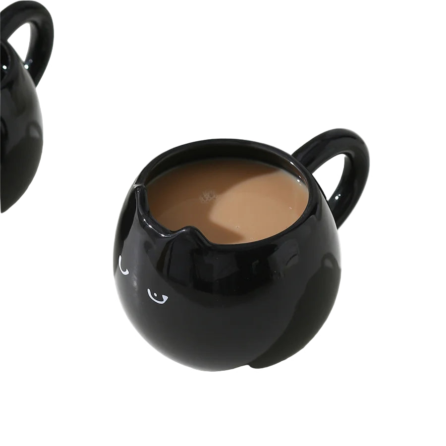 Black ceramic cat mug filled with a hot drink