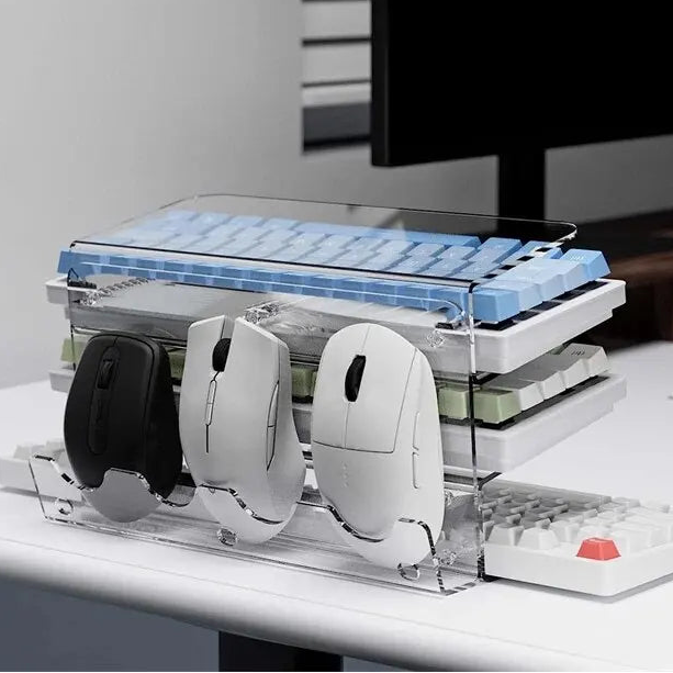 Clear acrylic keyboard and mouse organizer with multiple mice on a desk.