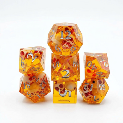 Seven translucent orange resin polyhedral dice with embedded skull details and numbered faces