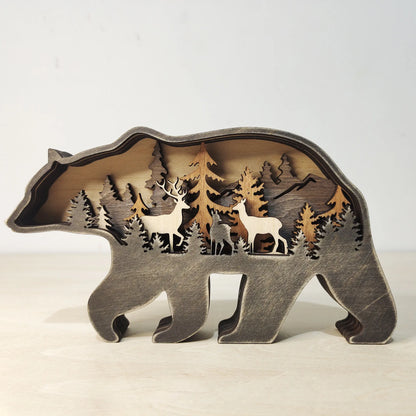 Wooden bear sculpture with cut-out designs of trees, deer, and mountains on a white background