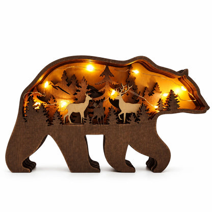 A bear-shaped wooden decorative light with laser-cut deer and forest silhouettes, illuminated from within by warm yellow fairy lights 