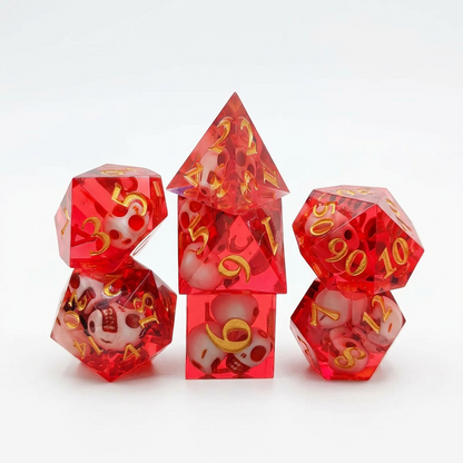 Seven translucent red resin polyhedral dice with embedded skull details and numbered faces