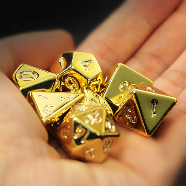 Shiny gold seven-piece tabletop RPG dice set held in a hand